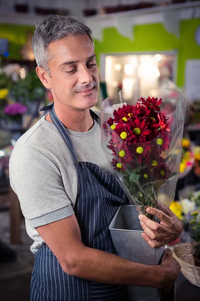 拿着红色向日葵束插在花瓶里的男性花店 — 图库照片