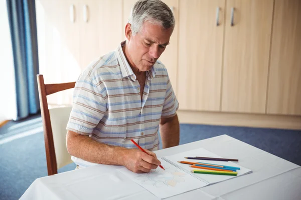 Uomo anziano che utilizza un libro da colorare — Foto Stock