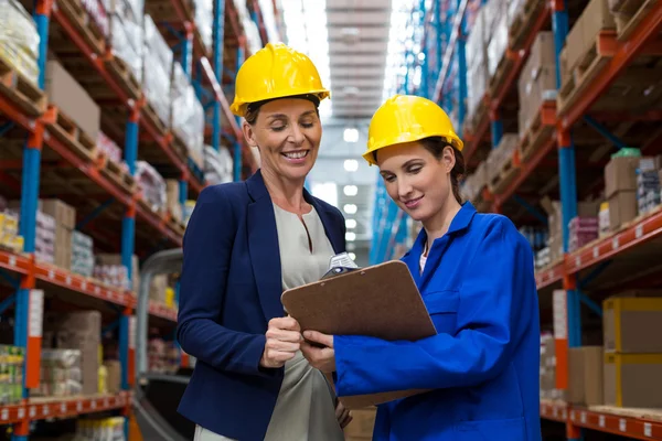 Female smiling coworkers looking at clipboard — Stock Photo, Image