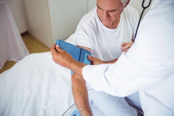 Pielęgniarka pomiar ciśnienia krwi, starszego mężczyzny — Zdjęcie stockowe