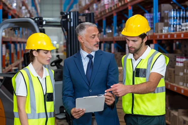 Manager and workers are talking and looking a tablet — Stock Photo, Image