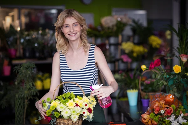 Kvinnliga florister sprutar vatten på blommor i blomsteraffären — Stockfoto