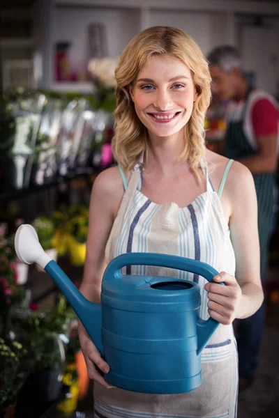 Lachende vrouw bloemist holding gieter — Stockfoto