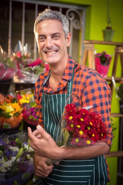 Fiorista maschio che tiene bouquet di fiori al suo negozio di fiori — Foto Stock