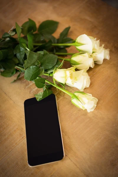 Rosas amarillas y smartphone en la mesa de madera —  Fotos de Stock
