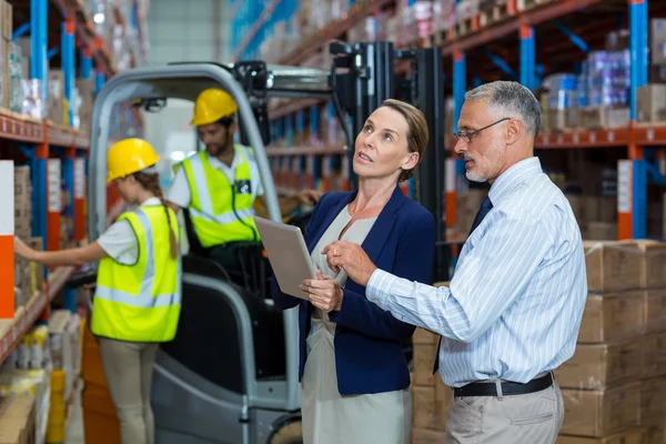 Managers are holding a tablet and looking shelves — Stock Photo, Image