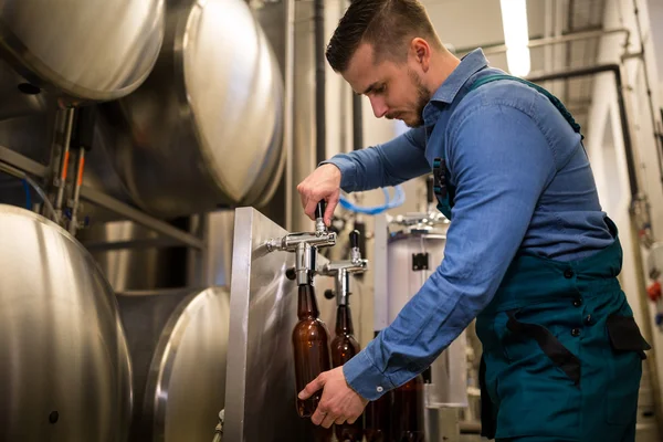 Brewer vullen bier in fles — Stockfoto