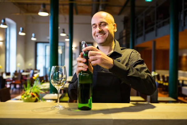 Cameriere aprendo una bottiglia di vino bianco — Foto Stock