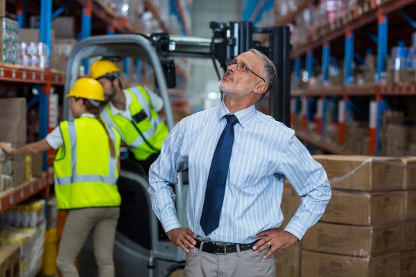 Focus of manager is looking shelves with hands on hips — Stock Photo, Image