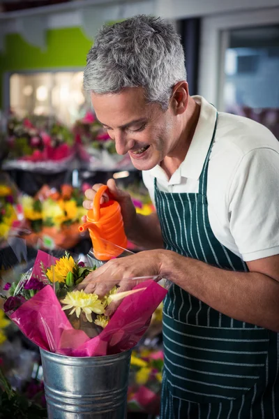 Male florist watering flowers with watering can — Stock Photo, Image