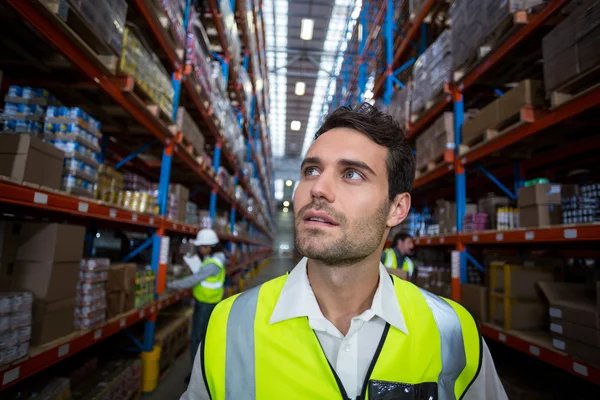 Trabajador en almacén mirando hacia arriba — Foto de Stock