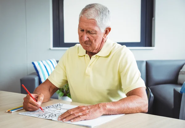 Uomo anziano che utilizza un libro da colorare — Foto Stock