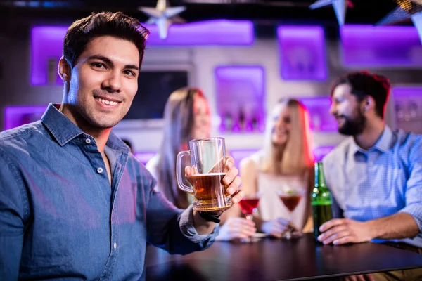 Uomo che beve un bicchiere di birra al bancone del bar — Foto Stock