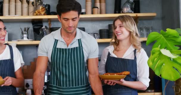 Kelner i kelnerki trzyma chleb drożdżówka — Wideo stockowe