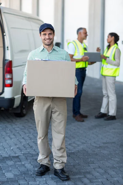Delivery man is holding a cardboard box — Stock Photo, Image