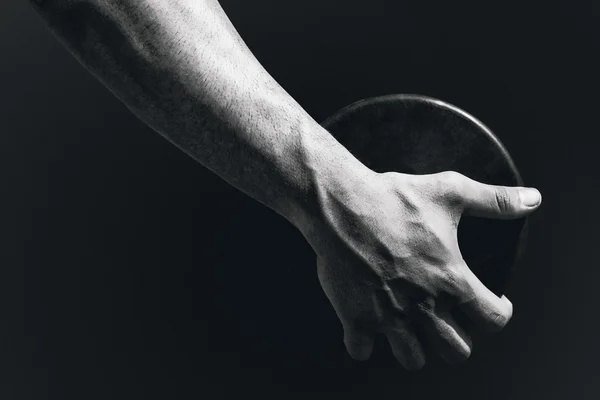 Sportman hand houdt een discus — Stockfoto