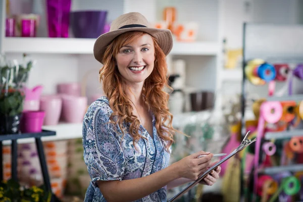 Lachende vrouw bloemist vaststellend op Klembord — Stockfoto