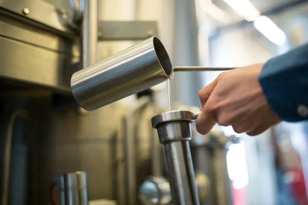 Brauer überprüft Bier in Brauerei — Stockfoto