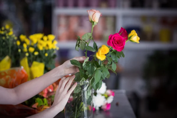 Florista feminina organizando buquê de flores em vaso — Fotografia de Stock