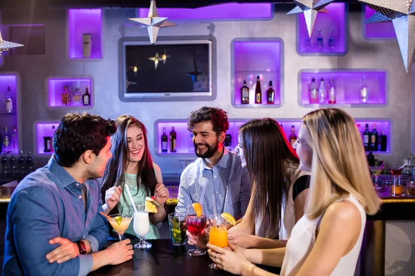 Amigos interactuando entre sí en el mostrador del bar — Foto de Stock