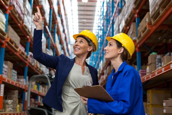 Lächelnde Mitarbeiterinnen schauen auf — Stockfoto