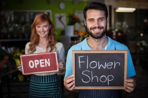 Man met leisteen met bloem winkel teken — Stockfoto