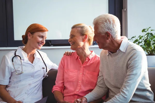 Enfermera y pareja de ancianos sentados en un sofá —  Fotos de Stock