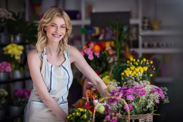 Feliz florista femenina de pie en la tienda de flores —  Fotos de Stock