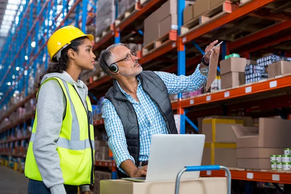 Manager e lavoratore sono alla ricerca di scaffali — Foto Stock