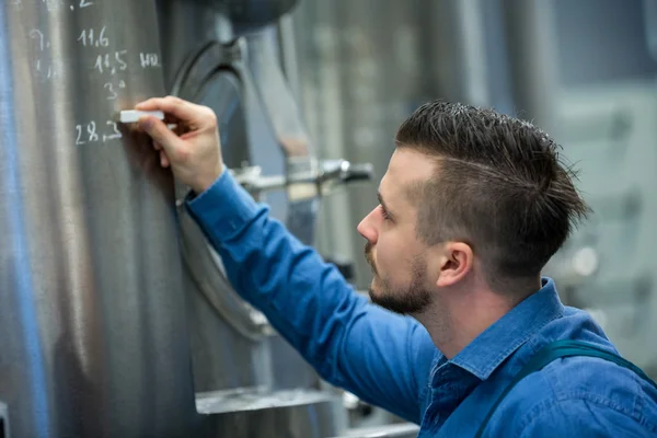 Maintained worker writing on tank — Stock Photo, Image