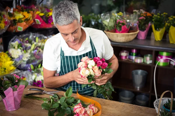 Blumenhändler hält Rosenstrauß in der Hand — Stockfoto