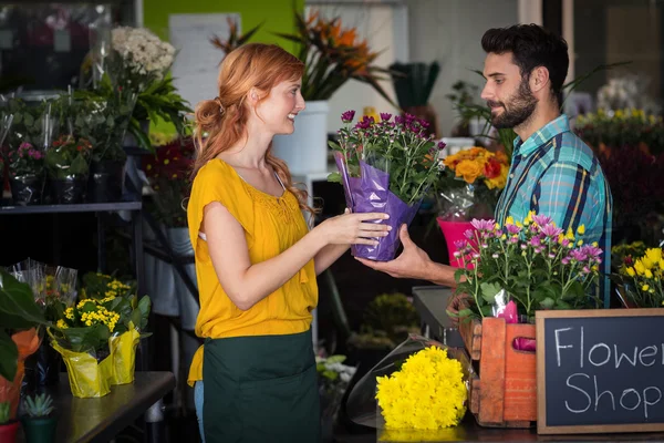 Kobiece Kwiaciarnia dając bukiet kwiatów dla człowieka — Zdjęcie stockowe