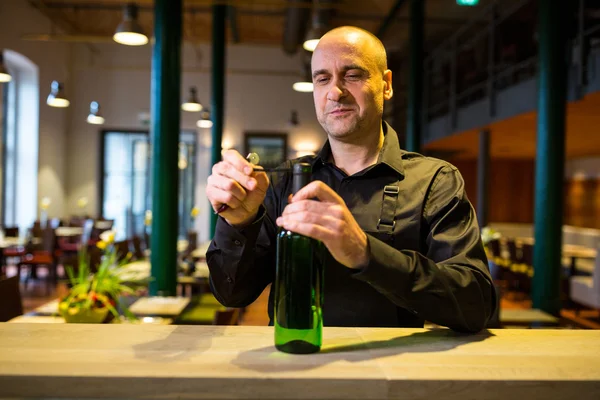 Servitören öppna en flaska vitt vin — Stockfoto
