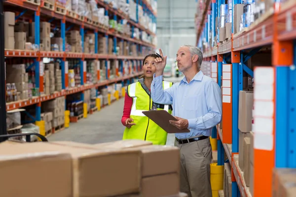 Gerente y trabajador están buscando estantes —  Fotos de Stock