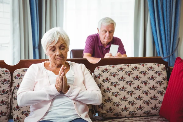 Allvarliga seniorer sitter på soffan och stol — Stockfoto