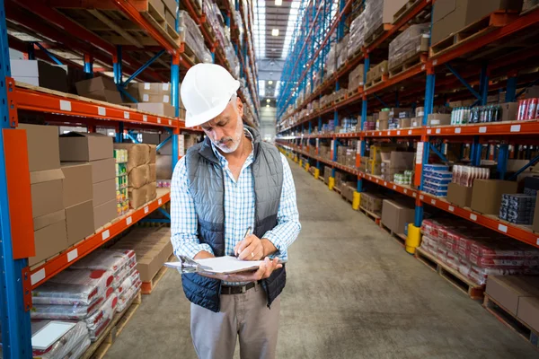 Arbeiter schreibt auf Klemmbrett — Stockfoto