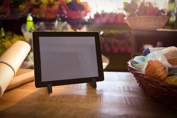 Cesta de mimbre y tableta digital en la mesa de madera — Foto de Stock