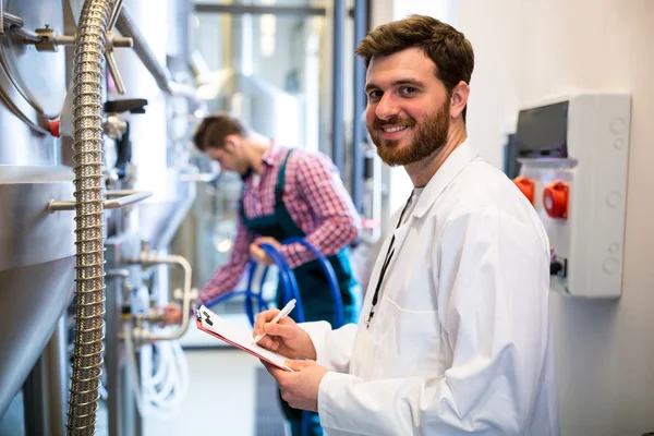 Travailleurs d'entretien examinant la machine de brasserie — Photo