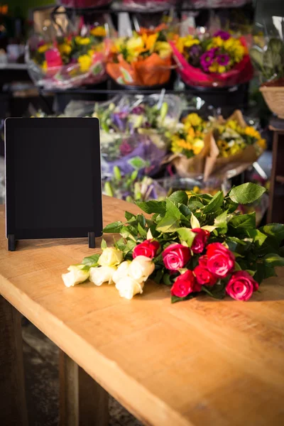 장미와 나무 테이블에 디지털 태블릿 — 스톡 사진