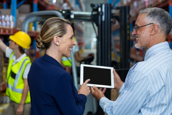 Vista trasera de la gente de negocios están buscando una tableta y sonriendo — Foto de Stock