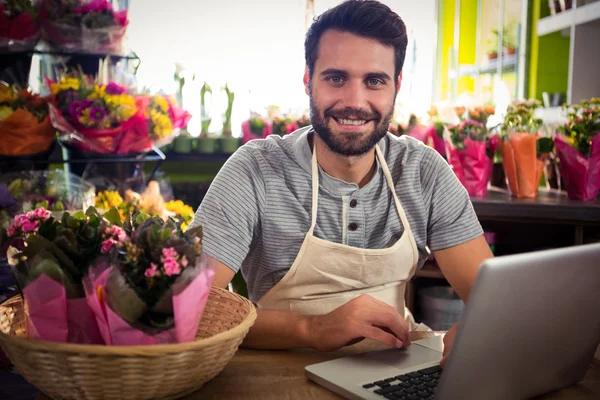 Floristería masculina usando laptop en su floristería —  Fotos de Stock