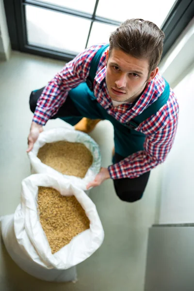 Cervejeiro com saco de grãos — Fotografia de Stock