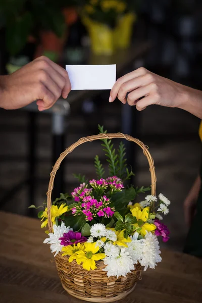 Mano de florista femenina dando tarjeta de visita al cliente —  Fotos de Stock