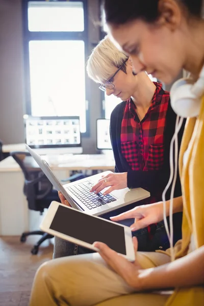 Twee vrouwelijke grafisch ontwerper met behulp van digitale Tablet PC- en laptop — Stockfoto