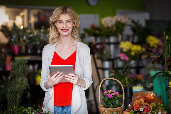 Feliz florista femenina sosteniendo tableta digital —  Fotos de Stock