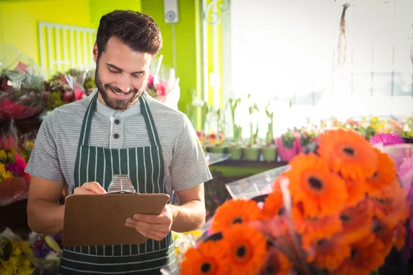 Manliga florist skriva och att göra anteckningar — Stockfoto