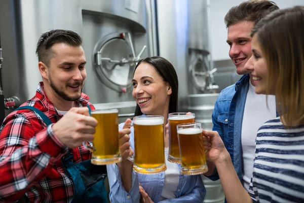 Brewers toasting beers at brewery — Stock Photo, Image