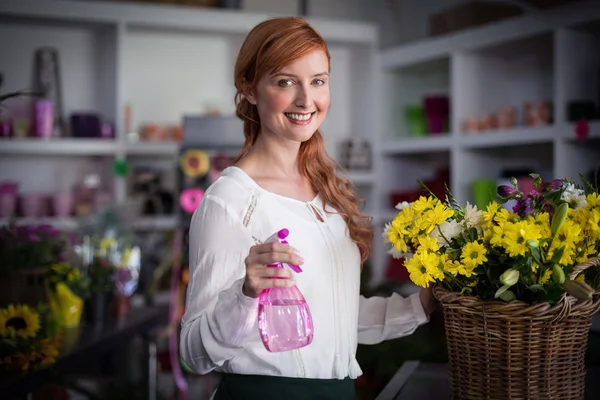 Vrouwelijke bloemist holding sproeiflacon — Stockfoto