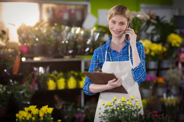 Floristería femenina usando teléfono móvil —  Fotos de Stock