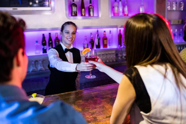 Barmaid serving drink to woman — Stock Photo, Image